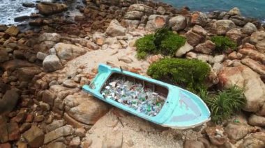 Hava manzarası, kayalık kıyı şeridi, kumlu gemi deniz kirliliği sorununu vurguluyor. Atılmış tekneler plastik şişelerle dolup taşar, deniz kenarları darmadağın olur. Kıyı çöplüğü sorunu, geri dönüşüm gerekliliği.