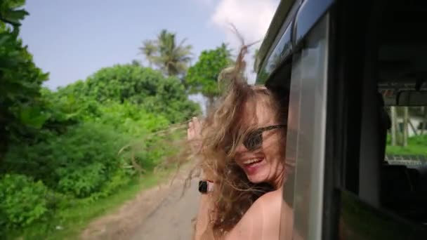 자동차 밖으로 머리와 자동차를 움직이는 창문에서 기대는 여행을 즐기는 클로즈업 — 비디오