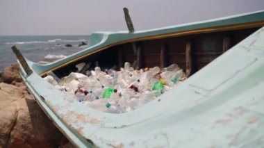 Terk edilmiş tekne çöplüğe dönüşür. Deniz çöpü sorunu. İnsan yapımı çöpün çevresel etkisi. Çöplük, insan plastik geri dönüşüm ekosistem sorunları. Deniz kıyısındaki okyanus enkazı.