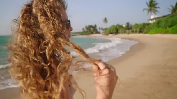바람에 머리를 서핑에 모델은 바닷가에 Airy 머리를 만집니다 자연스러운 빛나는 — 비디오