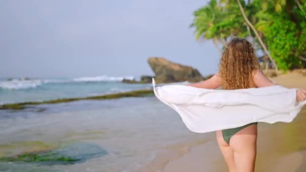 Trópusi Visszavonulásra Invitálja Nézőket Göndör Hajú Zöld Bikiniben Sétál Homokos — Stock videók