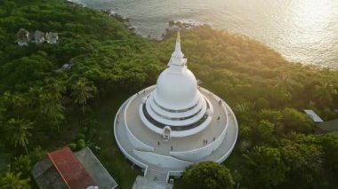 2023-03-15 - Unawatuna, Sri Lanka. Japon Barış Tapınağı. Altın ışık banyoları tapınak, huzurlu, ikonik ruhani bir yer. Gün batımında okyanus kenarında Budist tapınağının havadan görünüşü..