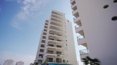 Yatırımcılar yerleşim birimlerini, potansiyel kârları ve pazar büyümesini araştırıyorlar. Modern yüksek katlı apartman, güneşli bir gün..