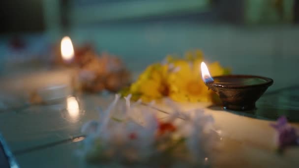 献身者は祈りを捧げ 霊性は共鳴する 寺院の床にキャンドルが点灯し 仏教の儀式の際に花の供え物の間に 伝統的な礼拝 信仰の雰囲気 観察された文化 — ストック動画
