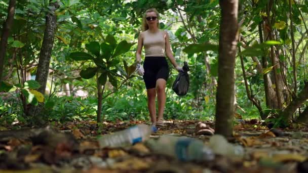 Активна Жінка Очищає Лісову Зону Збираючи Відкинуті Пляшки Гребінці Сміття — стокове відео