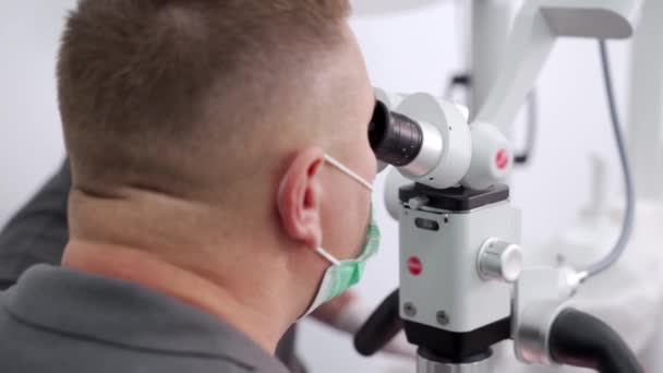 Zbliżenie Męskiego Naukowca Masce Medycznej Patrzącego Mikroskop Nowoczesnym Laboratorium Biotechnologicznym — Wideo stockowe