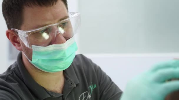 2020 14年 乌克兰马里乌波尔 丹坦尼亚牙科诊所 戴护目镜的男牙医检查老年人的牙齿 医生把假牙送到现代人的嘴里 后续行动 — 图库视频影像
