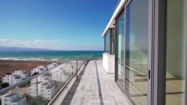 Üst düzey bir apartman dairesi, panoramik manzara. Geniş çatı katı balkonu sakin okyanusa, lüks sahil gayrimenkul yatırımlarına bakıyor..