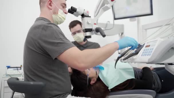 Mužský Zubař Asistentem Operujícího Pacienta Zub Pomocí Mikroskopu Moderní Zubní — Stock video