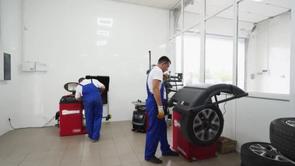 Trabalhadores Uniformizados Remover Substituir Pneus Equilíbrio Garagem Moderna Garantindo Segurança — Vídeo de Stock