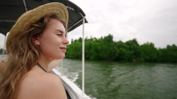 水生旅行のセレン女性 緑豊かな背景 リラクゼーションを体現し 自然を受け入れる わら帽子の女性は ゆったりとしたボートに乗って 川は穏やかに彼女の顔を気遣います スローモーション — ストック動画
