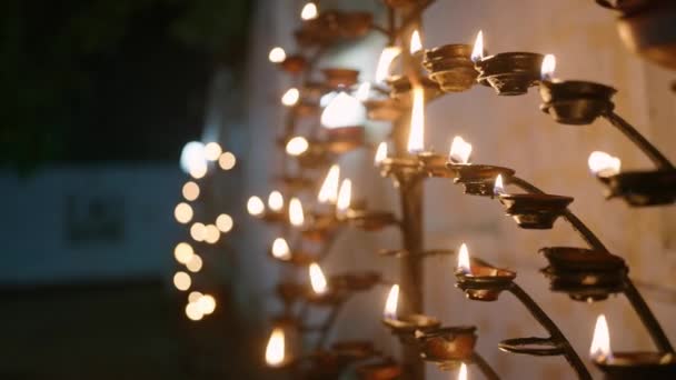 平和な炎のライトは精神的な雰囲気 お祝いを反映しています ヴェサクの夜の仏教寺院でオイルランプを燃やします 献身者は瞑想し 光で仏の教えを敬う — ストック動画