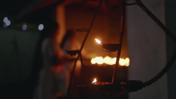 神聖な空間で礼拝するシルエットは 夕暮れ時に炎を燃やします 寺院の訪問者は献身の行為として提供物 オイルランプを提示します 静かな寺院で捉えられた文化的実践 精神的な雰囲気 — ストック動画