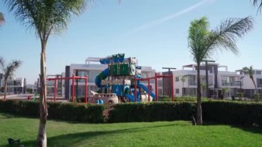 Lüks park tesisleri boş zaman ve dışarıda aile aktiviteleri sunuyor. Çocuklar lüks oyun sahasında slaytlarla, bahçelerin arasında salıncaklarla oynuyorlar..