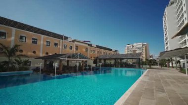 Geniş havuzlu, verandalı, güneşli gökyüzü kentsel çevrede, aileler için rahat yaşam alanı sunan modern yerleşim yerleri, konfor arayan profesyonel emekliler..