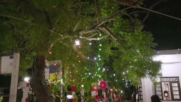 2023 Mirissa Sri Lanka 班达拉穆拉神庙专心致志的人聚集在一起 崇敬着 崇敬着装饰品 斯里兰卡一座佛教寺庙的树枝间挂着五彩缤纷的彩灯 庆祝卫塞节 — 图库视频影像
