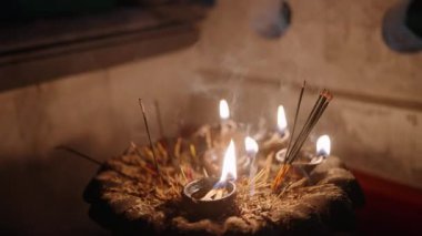 Tapınakta ruhani törende alevler. Geleneksel tütsü yakar, dumanlı ritüel ayrıntıları yakın plan. Meditasyon kolaylığı, inançlılar dua etmek için toplanır, huzur arar, ilahi anlar.