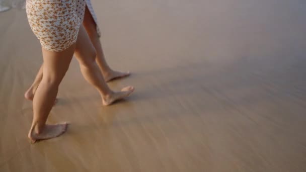 Πόδια Δύο Κοριτσιών Που Περπατούν Ξυπόλητα Στην Αμμώδη Παραλία Ηλιοβασίλεμα — Αρχείο Βίντεο