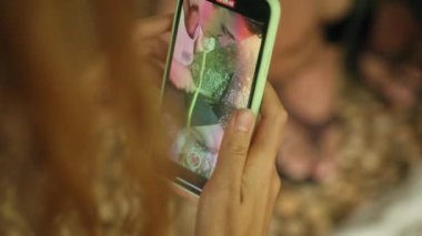 Akıllı telefondan geleneksel baharat üretimi gösteriliyor. Kadın, erkeğin tarçın kabuğunu işlediğini kaydediyor. Kapalı mekanda sanatsal aktivite, otantik işçilik. Yakın plan eller soyuluyor, baharat öğütülüyor..