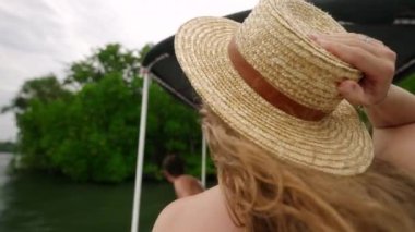 Rahatlamış turistler manzarayı gözlemler, sakin sularda eko turu deneyimlerler. Kıvırcık saçlı dişi nehir turundan hoşlanıyor, güneş şapkasını kavrıyor, doğayı izliyor. Solo gezgin nehir ortamını keşfediyor.