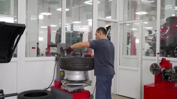 전문가는 타이어를 대체하고 스왑을위한 차량을 준비합니다 기계장치는 작업장에 타이어 변경자 — 비디오