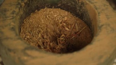 Geleneksel baharat işleme yöntemi. Esnaf, tarçın çubuklarını havanda elle öğütür. Otantik malzeme hazırlama, aşçılık kullanımı için aromatik toz oluşumuna yakın görüş.