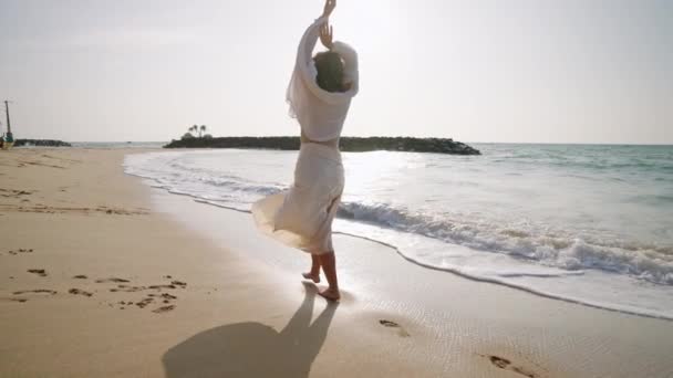 Νεαρή Γυναίκα Περπατά Ξυπόλητη Αφήνοντας Πατημασιές Στην Άμμο Θαλασσινό Σερφ — Αρχείο Βίντεο