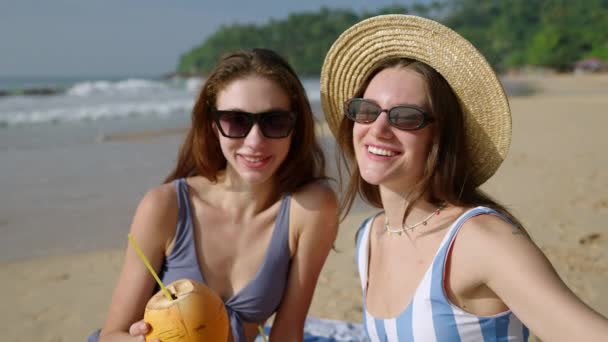 밀레니엄 여성들이 해변에서 코코넛 칵테일 사진을 여름날 해변에서 셀카를 선글라스에 — 비디오