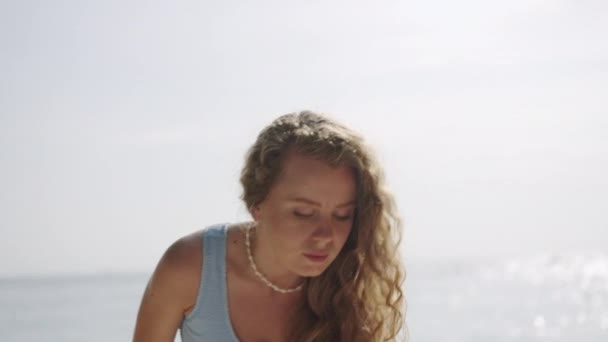 彻底使用防晒霜 享受海滨假期 优先使用Spf乳液防晒 女人从海里出来 在海滩上抓起防晒霜瓶 以保证皮肤的安全 慢动作 — 图库视频影像