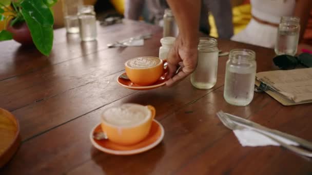 Handen Van Serveerster Serveert Kopjes Cappuccino Met Latte Kunst Houten — Stockvideo