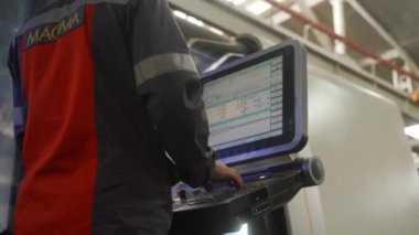 2021-09-23 - Mariupol, Ukrane. Magma fabrikası. Endüstriyel mühendis otomatik üretim sürecini ayarladı. Yetenekli operatör programları CNC makine hassasiyeti 6 taraflı değirmen işi, fabrika ayarları.