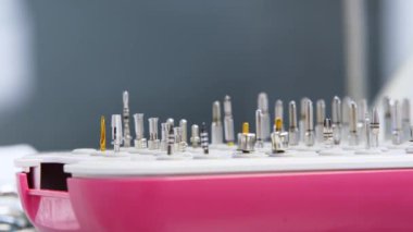 Diş aletleri için dişçi ofisindeki masada metal başlıklar var. Tıbbi masaya diş implantı yerleştirmek için stomatoloji araçları. Dişçilikte steril aletler. Makro, yakın plan..