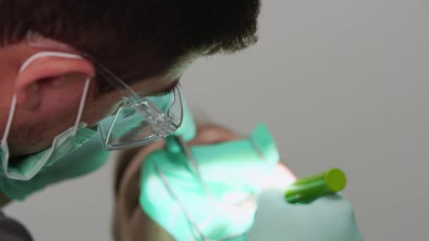 Homem Dentista Trata Homem Dente Paciente Com Represa Borracha Consultório — Vídeo de Stock