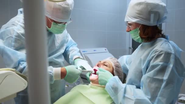 口腔外科医生护士在手术室做根管手术牙科医生在现代牙科诊所术后在牙龈上缝了针 牙科手术 牙科植入物安装 — 图库视频影像