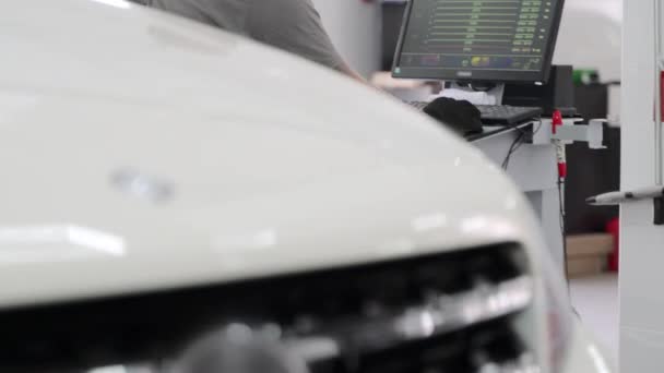 Techniker Analysiert Fahrzeugausrichtungsdaten Auf Dem Bildschirm Passt Einstellungen Für Optimale — Stockvideo
