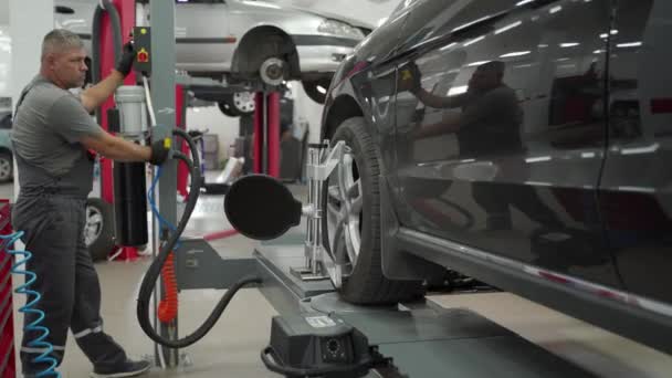 专家对现代汽车进行对齐检查 确保汽车的最佳安全性能 汽车机械师在车务中心为汽车车轮配备高精度设备 — 图库视频影像