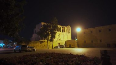 2021-10-29 - Famagusta, Kuzey Kıbrıs. Eski şehir merkezinde geceleri aydınlanan ortaçağ yapısı. Etrafı taştan duvarlar ve canlı çiçekliklerle çevrili taştan caddelerle çevrili..