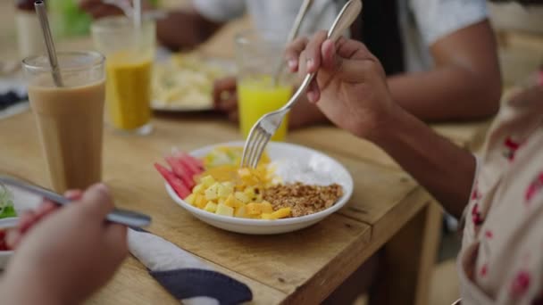 健康的な朝食 ブランチライフスタイル 手は新鮮なフルーツサラダをグラノーラ 木製のテーブルにヨーグルトで準備します 美味しい食事 栄養コンセプトのクローズアップ 朝食はジュース トロピカル — ストック動画