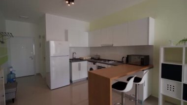 2021-01-18 - Iskele, Kuzey Kıbrıs. Caesar tatil yeri Modern kompakt mutfak, beyaz dolap, temel aletler, kahvaltı barı, şehir yaşamında alan verimliliği, uygun fiyatlı konut.