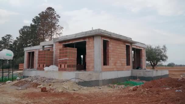2021年10月29日 北塞浦路斯伊斯凯莱 建造未完工的砖房地基 工人筑墙 潜在的购房者设想经济适用住房 抵押贷款利息 郊区发展 — 图库视频影像