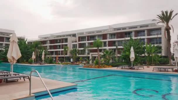 2021 キプロス北部イスカレ コルティヤードロングビーチリゾートラグジュアリーリゾートプール ラウンジチェア モダンな建築 トロピカルな雰囲気 不動産投資資産をアップスケール — ストック動画
