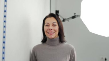 Beyaz kadın pozu, modern diş kliniğindeki kaplamaları ışıklandırma ekipmanıyla modellemeden önce çekilmiş. Ultraviyole beyazlatma işleminden önce kadın hastanın fotoğrafını çekiyorum. Kozmetik dişçiliği.