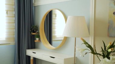 Modern minimalist apartman dekoru şık ayna, konsol masası, kapalı bitki dikme perdeleri ve modaya uygun lamba ve mobilya.