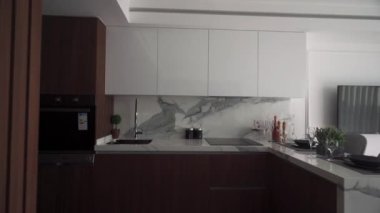 Resort Modern mutfak lüks apartman dairelerinde gösterişli tasarım, lüks aletler, mermer kaplama, verimli kentsel yaşam için akıllı ev teknolojisi entegrasyonu.