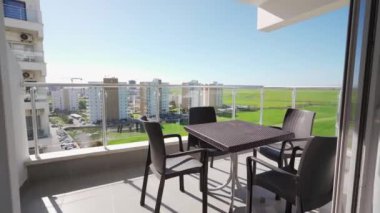 Balkon manzarası, yeşil alanlara tepeden bakan modern rattan mobilyalarla kentsel aparatı gösteriyor konut kiracıları için potansiyel sakin şehir kaçışı sorunları.