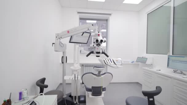 現代歯科クリニックの専門機器 歯科顕微鏡 ストーマトロジーオフィスで回転双眼鏡 歯を治療するための歯科顕微鏡を使用しています 歯の顕微鏡と義肢について — ストック動画
