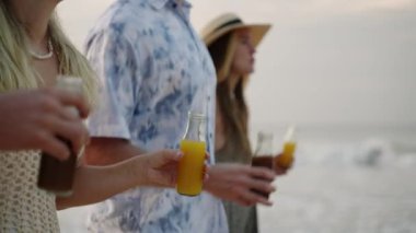 Bir şişe limonata, içen, kadeh kaldıran, deniz kıyısında yürüyen, tropik bir yolculukta rahatlayan gençlerin ellerinde. İki neşeli Kafkasyalı çift okyanus sahilinde içkinin ve serinlemenin tadını çıkarıyor..