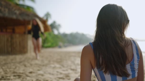 방갈로와 해변에서 코코넛 칵테일을주는 흐린된 여자는 해안에서 해변에서 화창한 — 비디오
