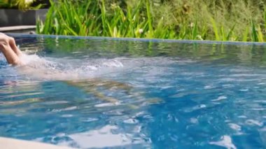 Güneşli alanda boş zaman aktivitesi, dalgıç su altını keşfeder, rahatlar. Kadınlar villadaki tropikal sonsuz havuzda lüks yüzmeyi severler. Egzotik tatil atmosferi, zengin yaşam tarzı. Yavaş çekim.