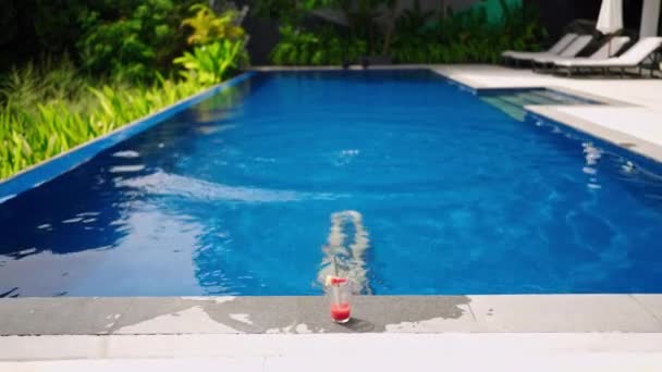 タンクの皮 リゾートの設定 エレガントな女性は 新鮮なカクテルを飲むために豪華なプール水泳 表面を楽しんでいます レジャー リラクゼーションブレンドエスケープ 太陽のラウンジは 開放感 休暇の雰囲気を伝えます — ストック動画